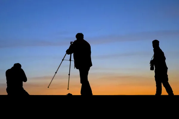 Sunrise silhouette of photographers shooting