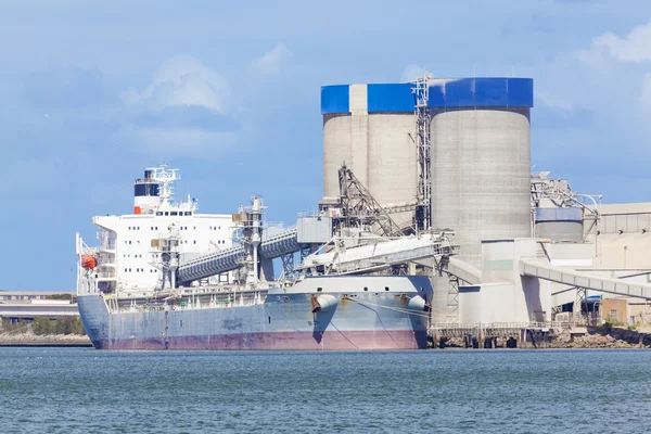 Cargo ship unloading at a cement plant