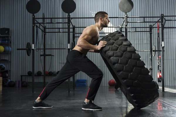 Bodybuilder flipping tire at the gym