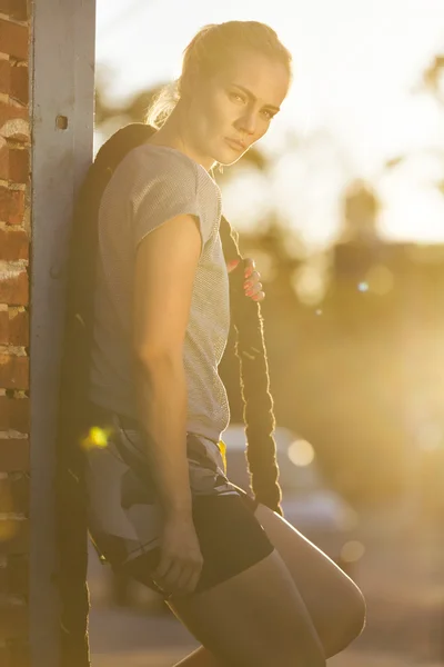 Sexy fitness trainer working out with ropes on the street