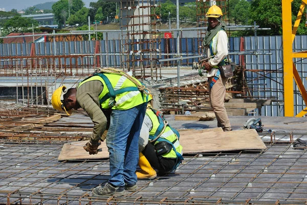 Construction workers fabricating floor slab reinforcement bar