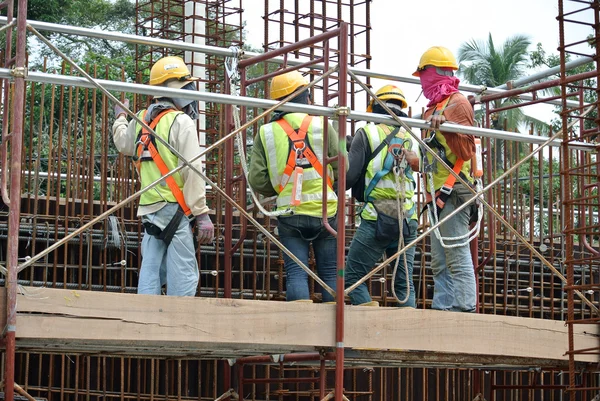Construction workers fabricate steel reinforcement for concrete wall at the construction site.