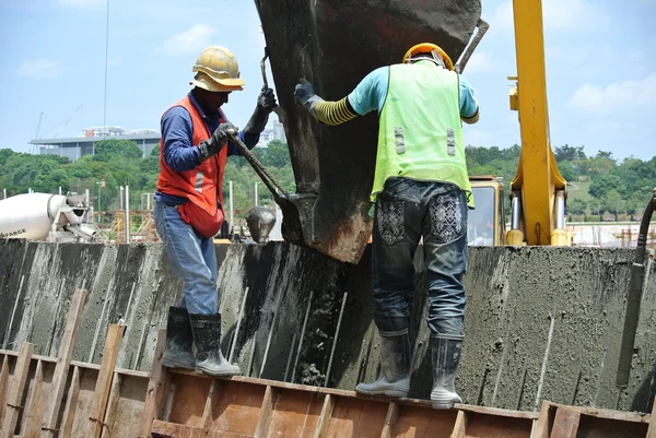 Group of construction workers casting concrete wall