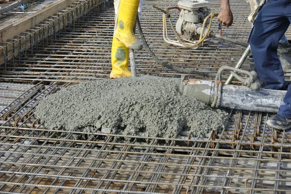 Construction Workers casting concrete using concrete hose