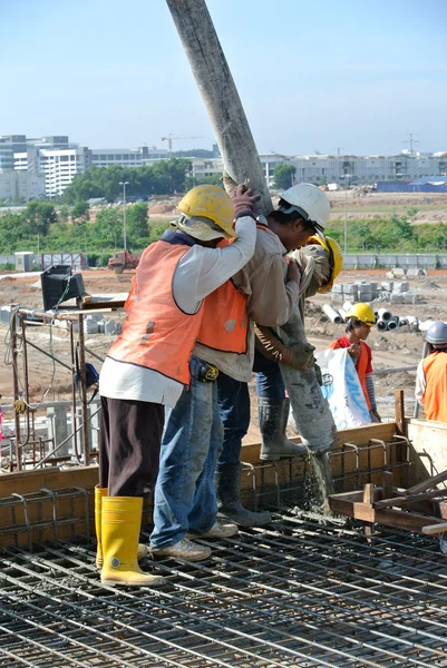 Construction Workers casting concrete using concrete hose