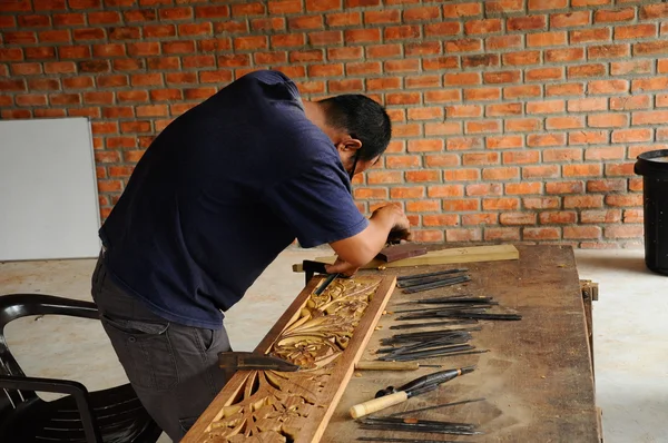 Skilled craftsman doing wood carving using traditional method