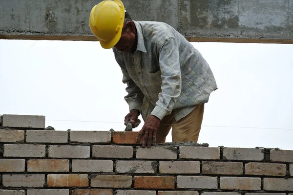 Construction workers laying bricks at construction site