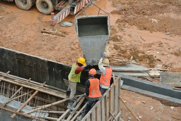 Group of construction workers casting reinforcement concrete wall