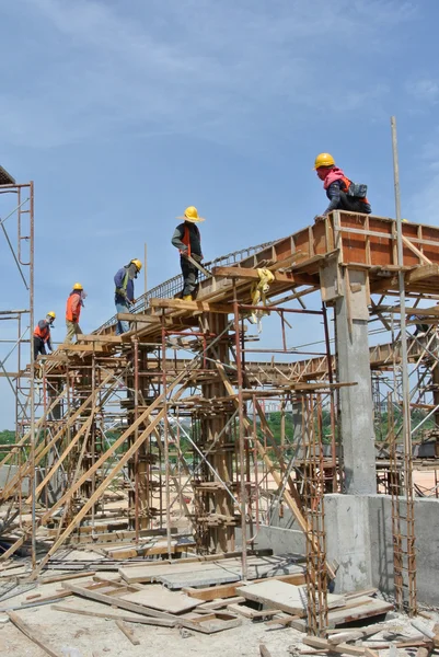 Construction workers fabricating beam reinforcement bar