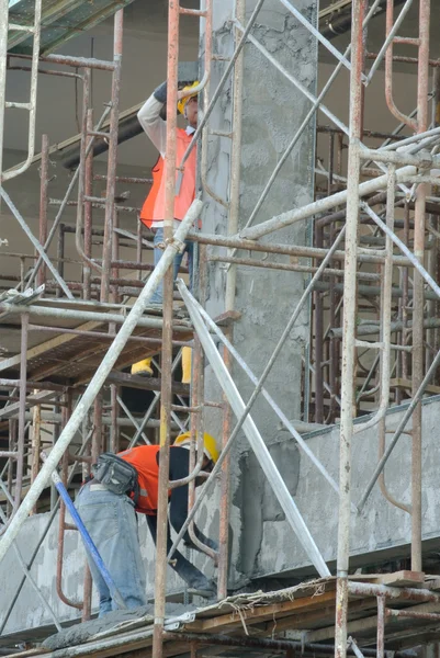 Group of construction workers plastering building wall