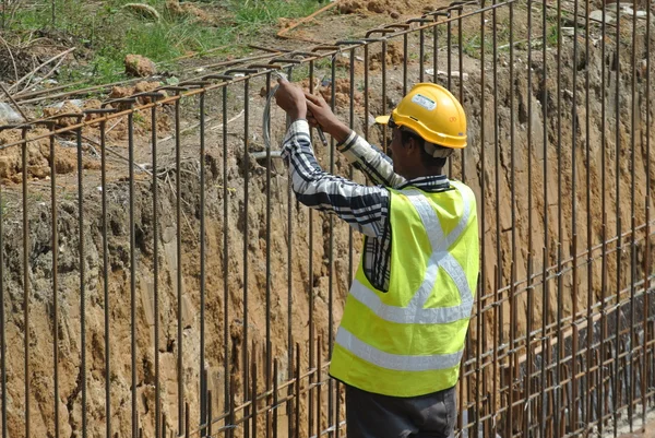 Construction workers fabricate retaining wall reinforcement bar at the construction site.