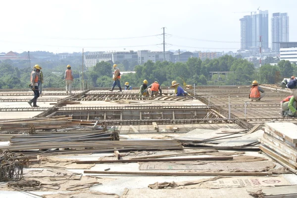 Group of construction workers fabricating floor slab and beam reinforcement bar and f ormwork