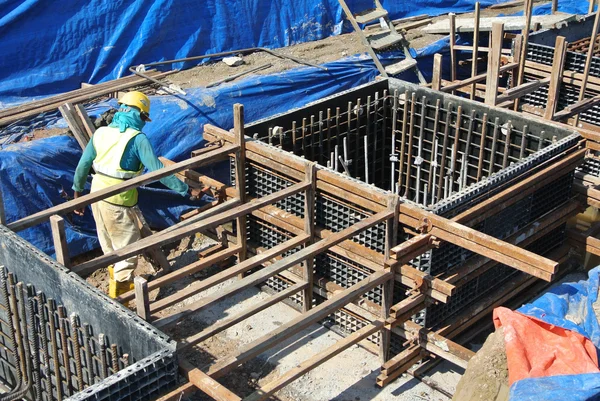 Construction workers installing pile cap formwork