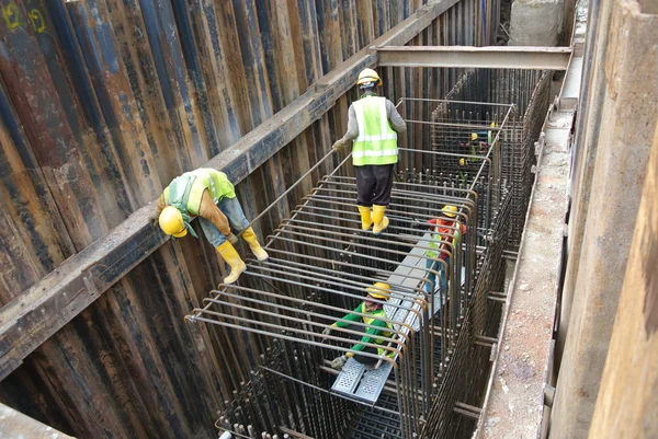 Group of construction workers fabricating pile cap steel reinforcement bar