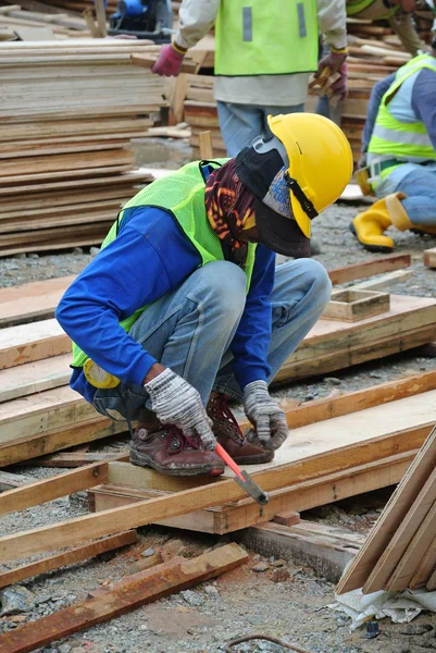 Carpenter fabricating timber form work at the construction site