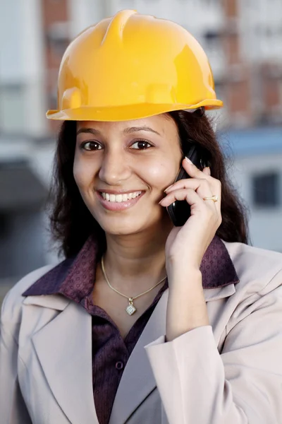 Indian female construction engineer talking on mobile