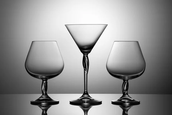 The glass of Martini and two glasses of brandy, On a mirror surf