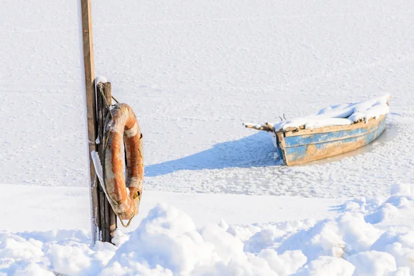 Old boat on ice. Winter landscape composition with old boat on i