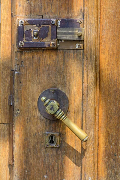 Vertical view with old doors closeup. Old doorknob at wood front