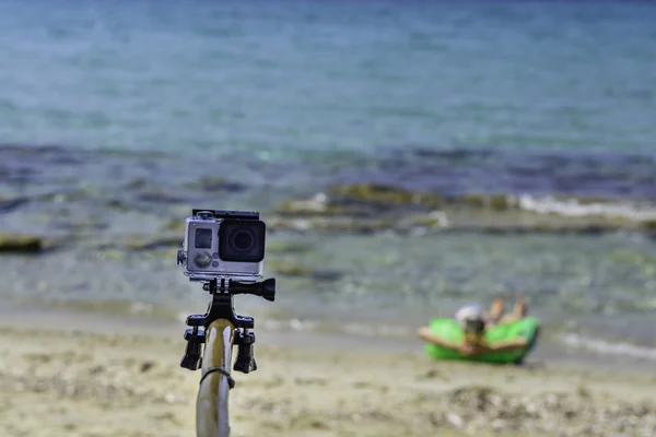 Travel concept - Action camera at sea , with bamboo selfie stick