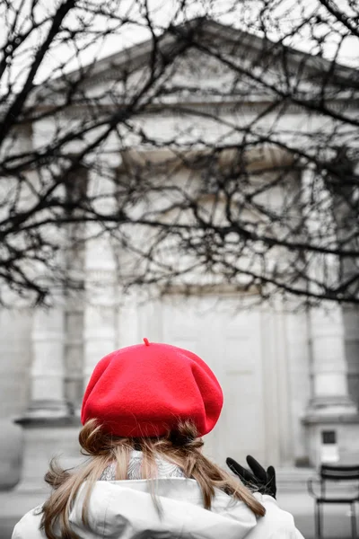 The woman in a coat and red hat at the autumn street. Vertical s