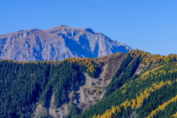 Rocky towny in autumn mountains. Rocky mountain peak with autumn