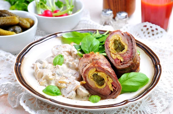 Roulade of beef stuffed with bacon, scrambled eggs, pickled cucumbers garnished with mushrooms stewed in sour cream.