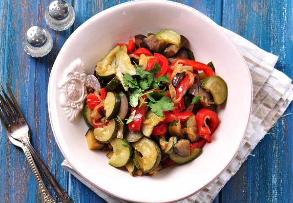 Stewed vegetables in a frying pan zucchini, eggplant, peppers and onions.