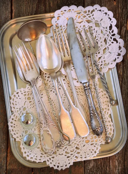 Antiques - cutlery, spoons, forks, knives on a tray,  image is tinted