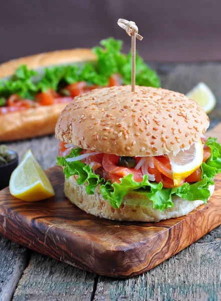 Burger with pickled salmon, lettuce, white onion and capers