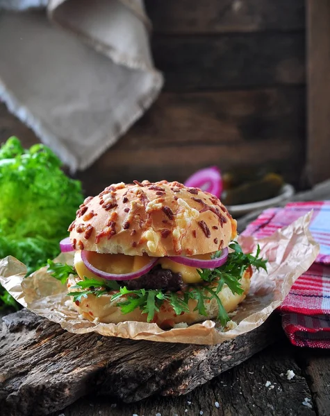 Juicy burger with beef, cheese, lettuce, sour cucumber, pickled onions and cheese loaf