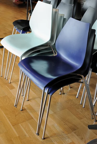 Groups of metal chairs are stacked in room