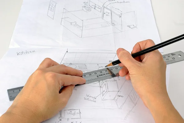 Hand is drawning sketch of the kitchen with pencil and ruler