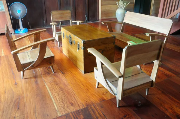 A teak wood console table and armchair on wooden floor