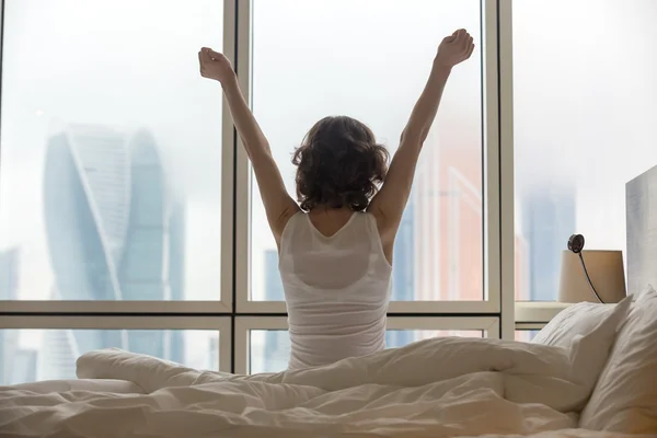 Young woman stretching after waking up