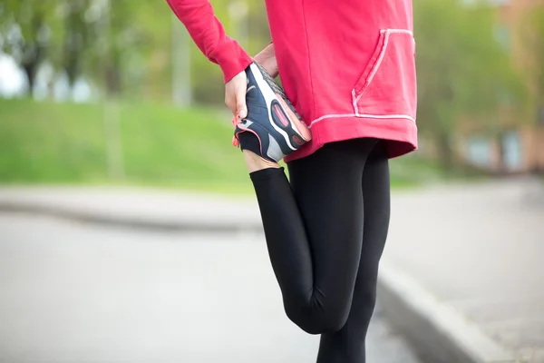 Jogger doing stretches before running practice. Close-up