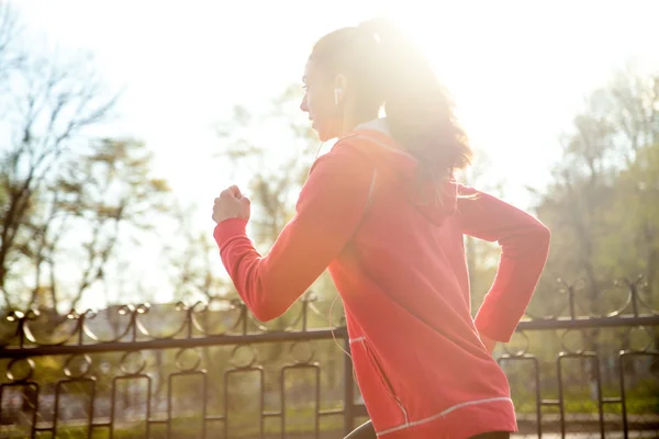 Attractive happy woman jogging in park