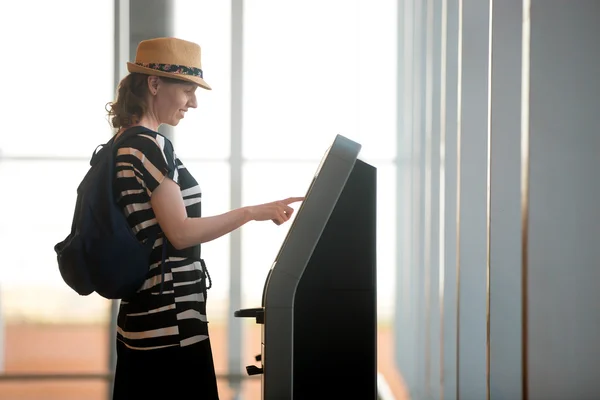 Woman doing self-check-in in airport
