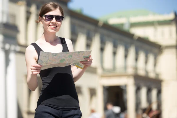 Young woman with map in the street