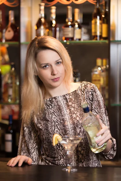 Blond girl pouring martini