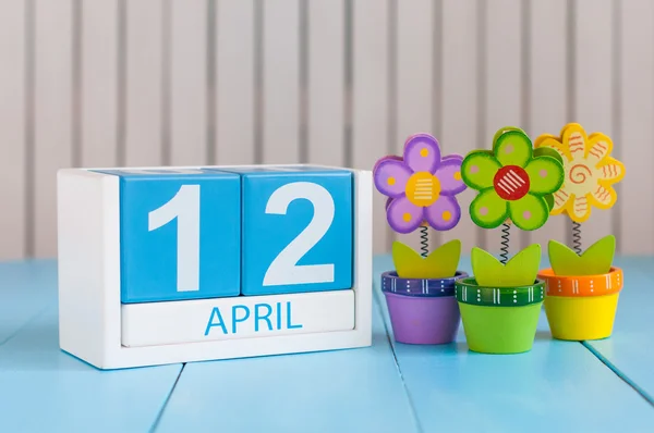 April 12th. Image of april 12 wooden color calendar on white background with flower. Spring day, empty space for text. Day Of Aviation and Cosmonautics. International DAY OF Human Space Flight