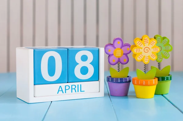 April 8th. Image of april 8 wooden color calendar on white background with flowers. Spring day, empty space for text. International Roma Gypsy Day