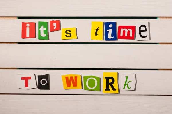 Its time to work - written with color magazine letter clippings on wooden board. Concept  image