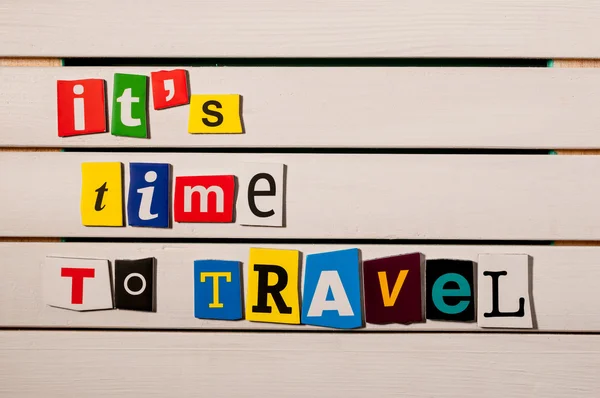 Time to Travel - written with color magazine letter clippings on wooden board