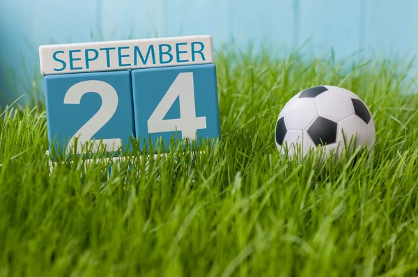 September 24th. Image of september 24 wooden color calendar on green grass lawn background. Autumn day. Empty space for text