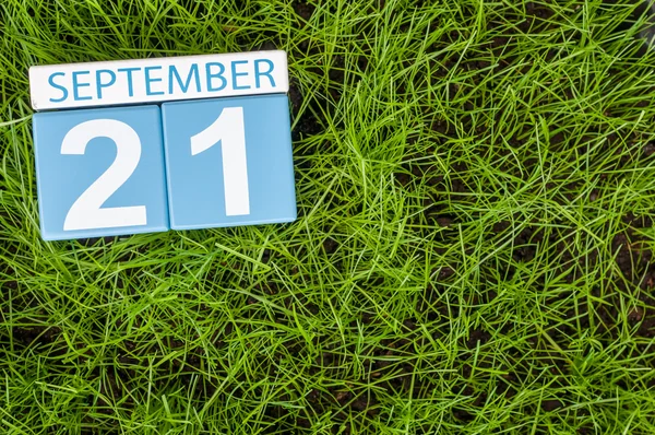 September 21st. Image of september 21 wooden color calendar on green grass lawn background. Autumn day. Empty space for text