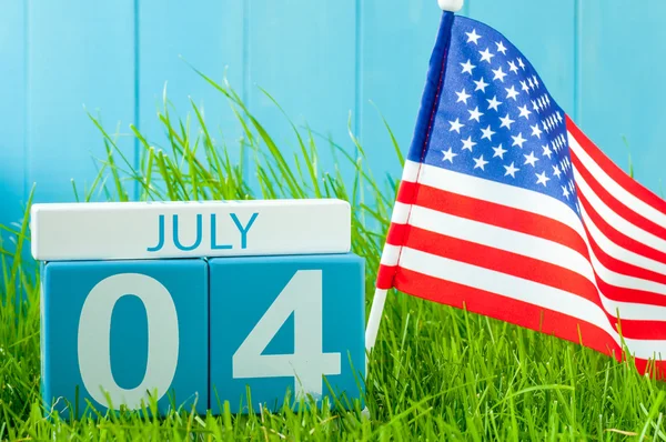 July 4th. Image of july 4 wooden color calendar on blue background with flag of the USA. Summer day. Independence Day Of America