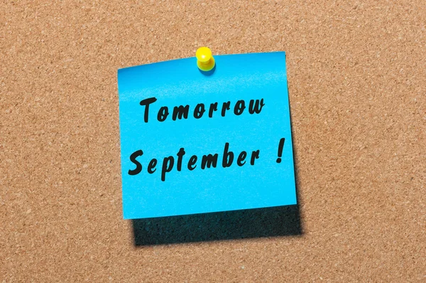 Tomorrow September. hand drawn lettering on color sticker pinned to notice corl board background