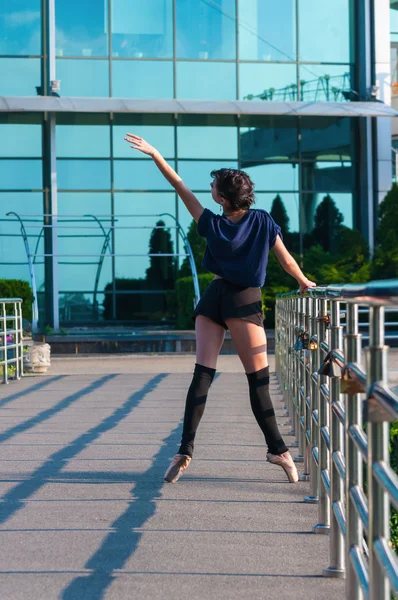 Ballerina dancing in casual clothes standing on tiptoes. Acrobatics, ballet, dance. Outdoor