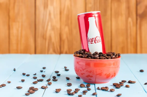 Kiev, Ukraine  April 2015. Coca-Cola in a bowl of coffee standing on blue table, dark wooden background. With empty space